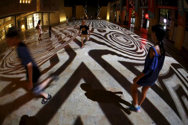 Children play within Pixels Wave 2015, a giant carpet of moving lights on the ground in an interactive virtual reality installation by Mexican-born experimental and multidisciplinary artist Miguel Chevalier, during the Malta International Arts Festival at the entrance to Valletta, Malta, July 17, 2015. (Photo by Darrin Zammit Lupi/Reuters)