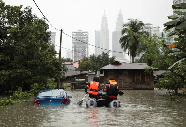 Malaysia Civil Defence Force members ride a boat to rescue the residents at a flooded area, following heavy rain fall in Kuala Lumpur, Malaysia, March 7, 2022. (Photo by Hasnoor Hussain/Reuters)