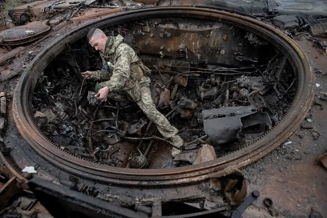 A Ukrainian soldier inspects a burnt Russian tank on April 2, 2022 in Dmytrivka, Kyiv region, Ukraine. After 5 weeks of war, Russian forces around the capital have been pushed back in some places by Ukrainian counter-attacks. But shelling persists in suburbs of Kyiv, which, like much of the country, remains vulnerable to Russian air strikes. (Photo by Alexey Furman/Getty Images)