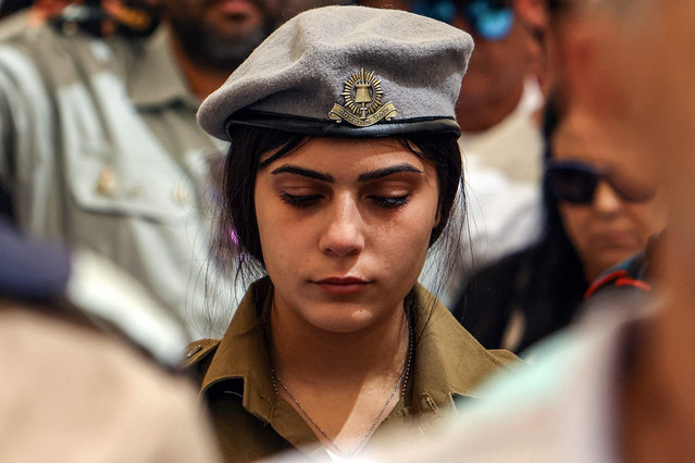 Israeli soldiers and mourners observe two minutes of silence during a ceremony for Memorial Day (Yom HaZikaron) at the military cemetery in Beersheba on April 25, 2023. Israel marks Remembrance Day to commemorate 24,213 fallen soldiers and victims of attacks recorded since 1860 by the Ministry of Defence, just before the celebrations of the 75th anniversary of its creation according to the Jewish calendar. (Photo by Gil Cohen-Magen/AFP Photo)