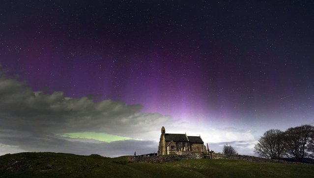 The aurora borealis, also known as the Northern Lights, illuminate the sky just before midnight over St Aidan's church in Thockrington, Northumberland, UK on Wednesday, April 17, 2024. (Photo by Owen Humphreys/PA Images via Getty Images)