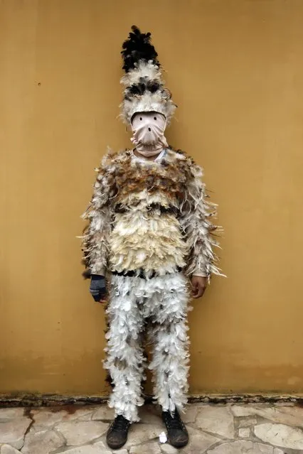 Alfredo Ortega poses for a photo in his bird-feather suit after attending a Mass commemorating the feast day of St. Francis Solano, in Emboscada, Paraguay, Friday, July 24, 2015. Paraguayan Catholics honored the Spanish friar also known as St. Francisco Solanus in a a mix of Indian and Catholic beliefs. The festival begins with a Mass, continues with a procession of the diminutive wooden statue of St. Francis, and ends with pledges covered in feathers from head to toe, dancing with fellow parishioners. (Photo by Jorge Saenz/AP Photo)