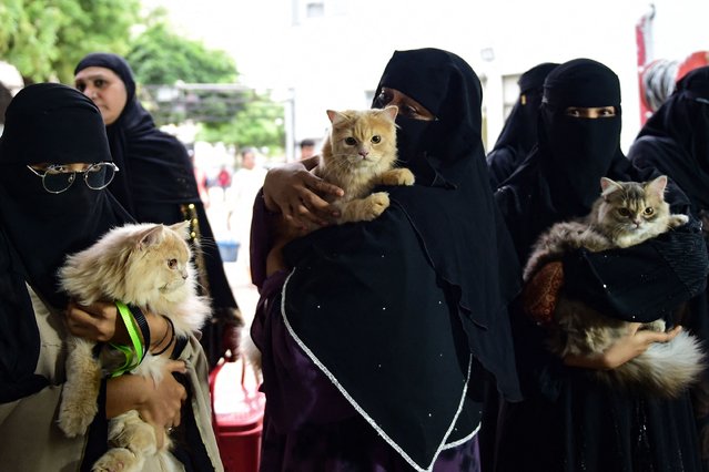 Women with their cats align at a free vaccination camp on International Cat Day, in Ahmedabad on August 8, 2024. (Photo by Sam Panthaky/AFP Photo)