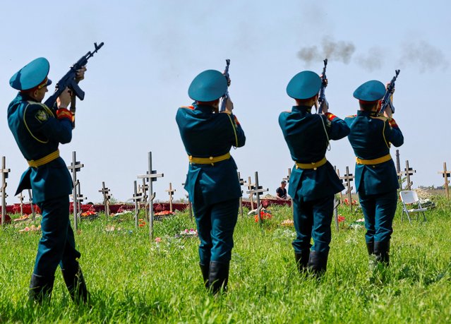 Guards of honour fire weapons during a funeral ceremony to bury the remains of sixty service members of the Russian armed forces and three civilians, who were killed in the course of Russia-Ukraine conflict, at a cemetery in Luhansk, Russian-controlled Ukraine on May 18, 2023. (Photo by Alexander Ermochenko/Reuters)