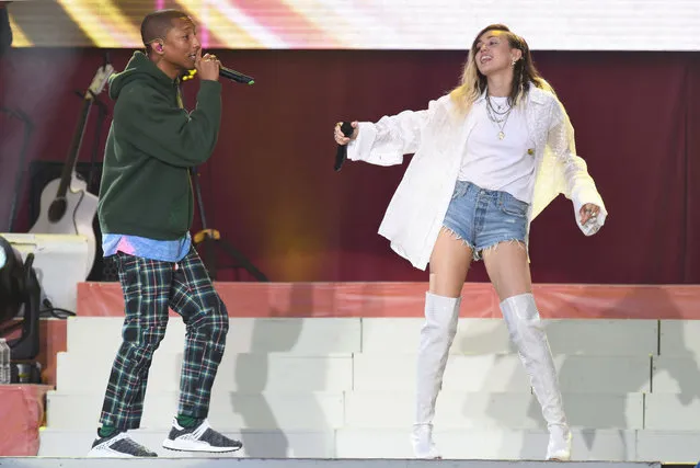 In this Sunday, June 4, 2017, handout photo provided by Dave Hogan for One Love Manchester, singers Pharrell Williams, left, and Miley Cyrus perform at the One Love Manchester tribute concert in Manchester, north western England, Sunday, June 4, 2017. One Love Manchester is raising money for those affected by the bombing at the end of Ariana Grande's concert in Manchester on May 22, 2017. (Photo by Dave Hogan via AP Photo)