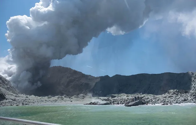 This handout photograph courtesy of Michael Schade shows the volcano on New Zealand's White Island spewing steam and ash minutes following an eruption on December 9, 2019. New Zealand police said at least one person was killed and more fatalities were likely, after an island volcano popular with tourists erupted on December 9 leaving dozens stranded. (Photo by Michael Schade/AFP Photo/Handout)