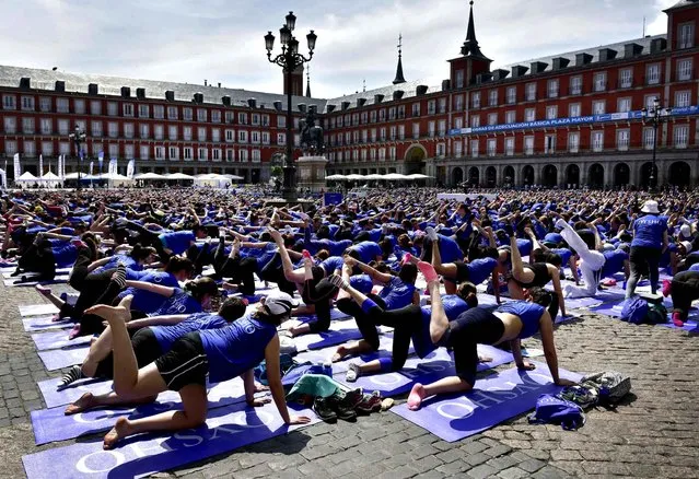 Thousands participants gather at the Plaza Mayor square in Madrid to take part in the 4th Free Yoga Masterclass in Madrid, the biggest outdoor yoga event in Spain on June 4, 2016. (Photo by Gerard Julien/AFP Photo)