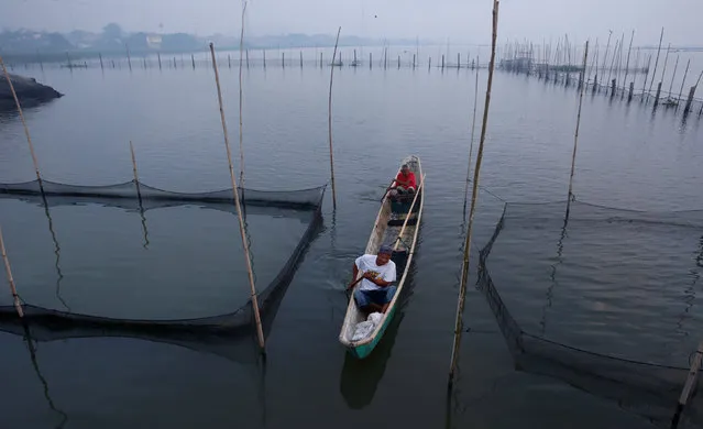 Fishermen row their boat as they inspect their fishpen during the New Year in Manila, Philippines January 1, 2017. (Photo by Erik De Castro/Reuters)