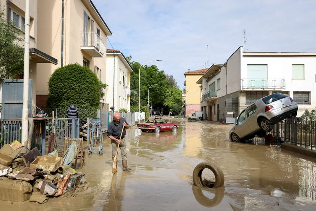 A resident removes mud and debris after heavy rains hit Italy's Emilia Romagna region, in Faenza, Italy on May 18, 2023. (Photo by Claudia Greco/Reuters)