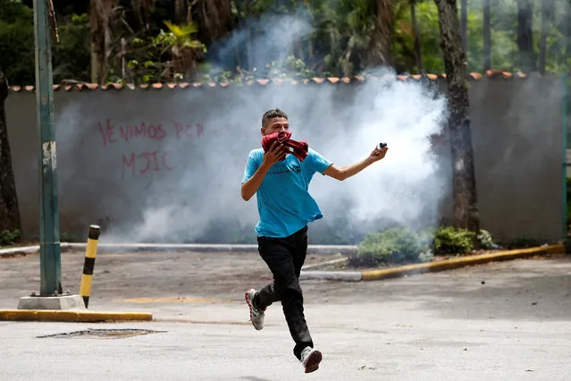 A demonstrator holds a tear gas canister as they clash with riot police officers during a protest called by university students against Venezuela's government in Caracas, Venezuela, June 9, 2016. (Photo by Carlos Garcia Rawlins/Reuters)