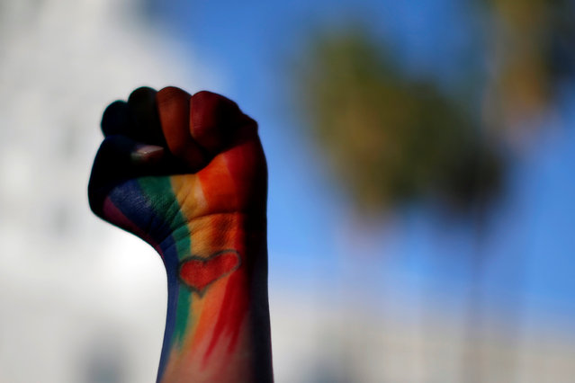 Dominique Hernandez holds up her fist painted in the colors of a rainbow, with a heart on her pulse, attends a vigil in memory of victims one day after a mass shooting at the Pulse gay night club in Orlando, in Los Angeles, California, U.S. June 13, 2016. (Photo by Lucy Nicholson/Reuters)
