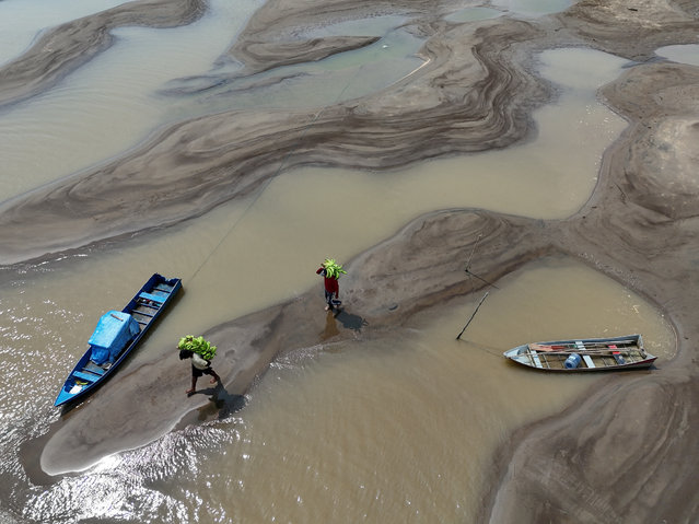 A drone view shows people carrying bananas walking over sandbanks due to the drought affecting the Solimoes River in Manacapuru, Amazonas state, Brazil on September 14, 2024. (Photo by Bruno Kelly/Reuters)