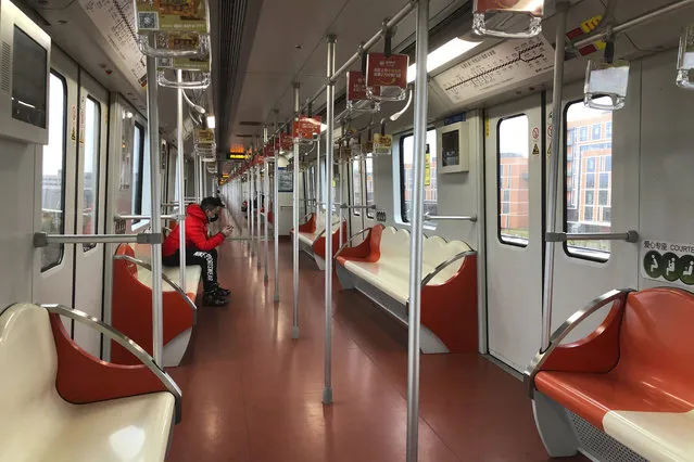A man wears a face mask as he rides a nearly empty subway train near the Shanghai Disney Resort, which announced that it will be closed indefinitely from Saturday, in Shanghai, Saturday, January 25, 2020. China's most festive holiday began in the shadow of a worrying new virus Saturday as the death toll surpassed 40, an unprecedented lockdown that kept people from traveling was expanded to more than 50 million residents and authorities canceled a host of Lunar New Year events. (Photo by Fu Ting/AP Photo)