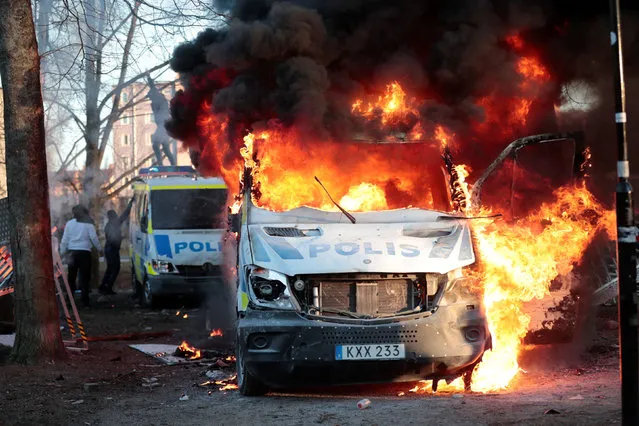 Police vans are on fire during a counter-protest in the park Sveaparken in Orebro, south-centre Sweden on April 15, 2022, where Danish far-right party Stram Kurs had permission for a square meeting on Good Friday. (Photo by Kicki Nilsson/TT News Agency/AFP Photo)