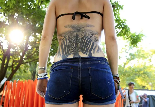 Lea Chartier, 20, from France shows her tattoo during the Sziget music festival on an island in the Danube River in Budapest, Hungary, August 14, 2015. (Photo by Bernadett Szabo/Reuters)