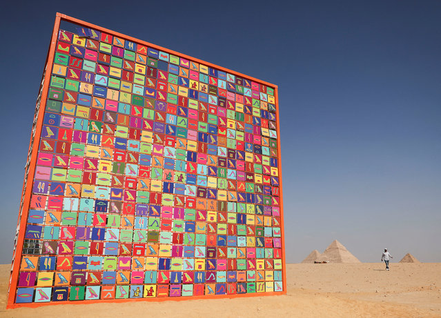 A tourist walks next to an art installation by visual artist Ik Joong Kang titled “Four Temples” during the fourth edition of “Forever is Now”, an international art exhibition that reimagines Egypt's ancient civilization through contemporary art in Giza Pyramids, on the outskirts of Cairo, Egypt on November 4, 2024. (Photo by Amr Abdallah Dalsh/Reuters)