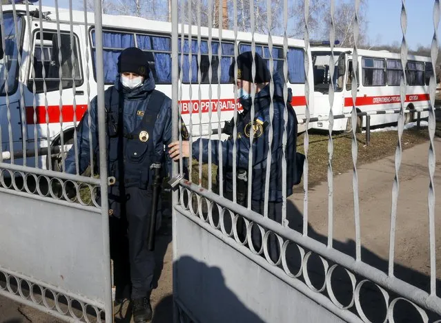 A Ukrainian National Guards soldier secures the gate of the sanitarium where evacuees from the Chinese city of Wuhan are to be quarantined because they fear becoming infected, in Novi Sanzhary village, Poltava region, in Novi Sanzhary, Ukraine, Friday, February 21, 2020. Ukraine's effort to quarantine more than 70 people evacuated from China over the outbreak of a new virus has plunged into chaos as local residents opposing the move hurled stones at buses carrying evacuees and clashed with police. (Photo by Efrem Lukatsky/AP Photo)