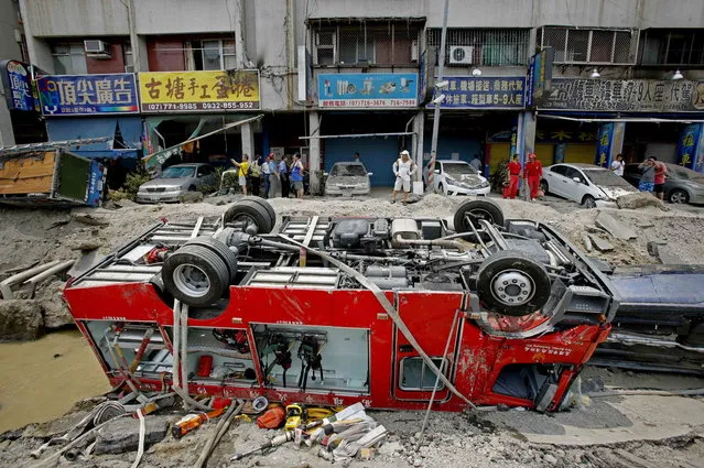 A destroyed fire truck is seen overturned in the rubble after massive gas explosions in Kaohsiung, Taiwan, Friday, August 1, 2014. A series of underground explosions about midnight Thursday and early Friday ripped through Taiwan's second-largest city, killing scores of people, Taiwan's National Fire Agency said Friday. (Photo by Wally Santana/AP Photo)