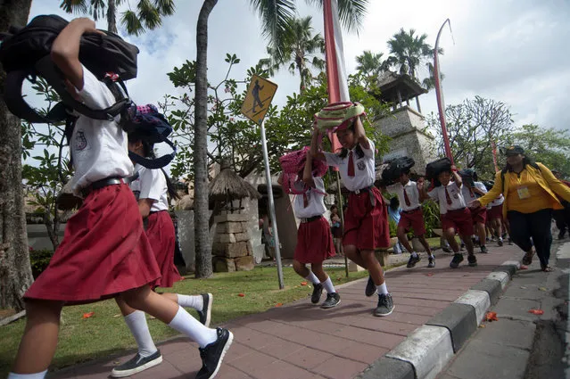 Students protect their heads as they run to a safe place during tsunami drill at Tanjung Benoa school in Badung, Indonesia Bali resort island, August 15, 2017 in this photo taken by Antara Foto. (Photo by Nyoman Budhiana/Reuters/Antara Foto)