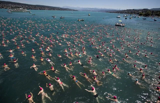 People take part in the annual public Lake Zurich crossing swimming event in Zurich, Switzerland on July 13, 2022. (Photo by Arnd Wiegmann/Reuters)