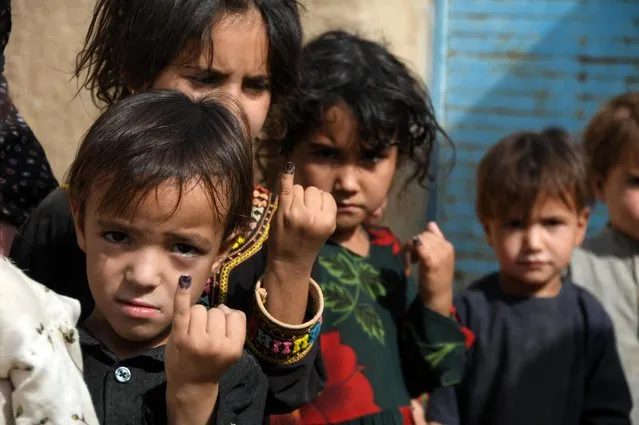 Children show their fingers marked with ink after having polio vaccine at a campaign in Kandahar on June 28, 2022. (Photo by Javed Tanveer/AFP Photo)