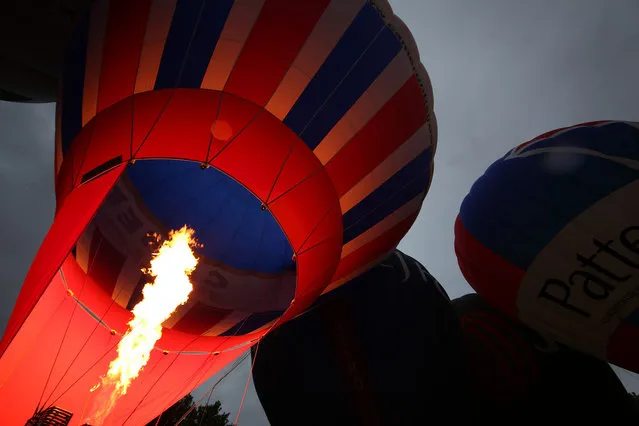 Hot air balloons are inflated in Queen Square ahead of the Bristol International Balloon Fiesta on August 5, 2014 in Bristol, England. Now in its 36th year, the Fiesta is Europe's largest annual hot air balloon event in the city that is seen by many as the home of modern ballooning.  (Photo by Peter Macdiarmid/Getty Images)