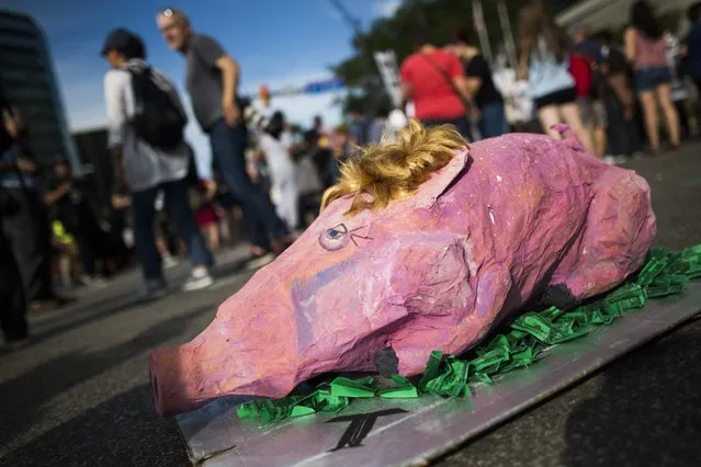 A paper mache pig meant to mock Donald Trump sits on display at a protest against the Republican presidential candidate before the start of the Republican National Convention in Cleveland, Ohio, USA, 17 July 2016. Numerous protest groups are expected in Cleveland throughout the four-day-long convention. (Photo by Jim Lo Scalzo/EPA)