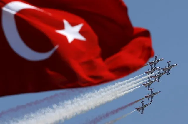 Turkish Stars, the aerobatic team of the Turkish Air Force, perform a manoeuvre during a ceremony marking the 93rd anniversary of Victory Day in Ankara, Turkey, August 30, 2015. (Photo by Umit Bektas/Reuters)
