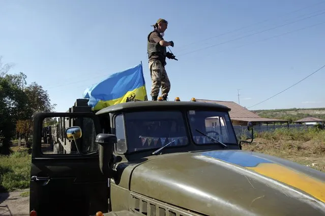 A Ukrainian serviceman stands on a military truck as he mans a checkpoint in Luhansk region August 20, 2014. (Photo by Valentyn Ogirenko/Reuters)