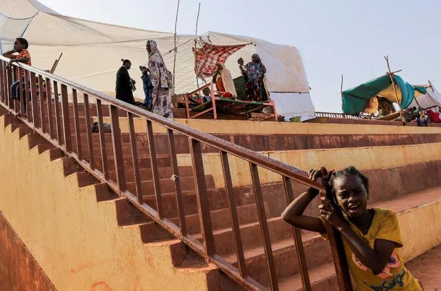 People rest inside a stadium after sustaining water damage to their houses during floods in Al-Managil locality in Jazeera State, Sudan on August 23, 2022. (Photo by Mohamed Nureldin/Reuters)