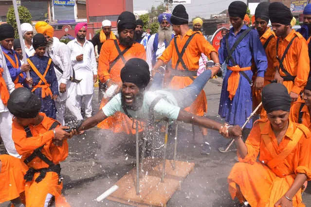 An Indian Nihang, a religious Sikh warrior, deomonstrates Sikh martial arts skills known as “Gatka” during a march to mark the 354th birth anniversary of the Sikh warrior Shaheed Baba Jiwan Singh at the Golden temple in Amritsar on September 3, 2015. The Sikhs are celebrating Shaheed Baba Jiwan Singh, a famous warrior from the Sikh religion who lived during the 17th century. (Photo by Narinder Nanu/AFP Photo)