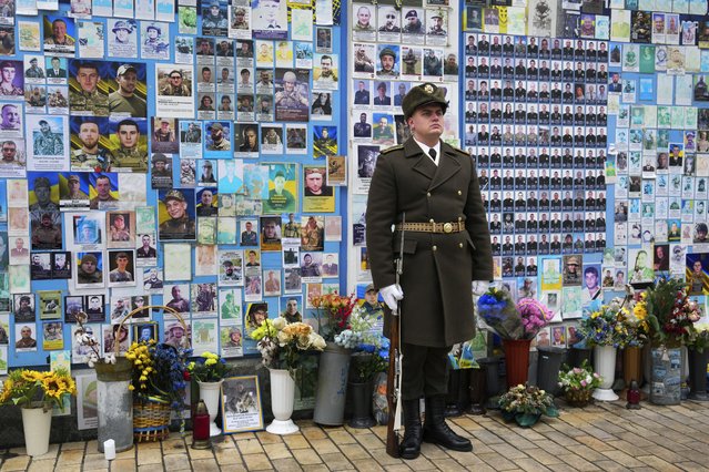 A soldier stands in front of The Wall of Remembrance of the Fallen for Ukraine at St Michael's Square in Kyiv, Ukraine Thursday, January 16, 2025. (Photo by Carl Court/Pool Photo via AP Photo)