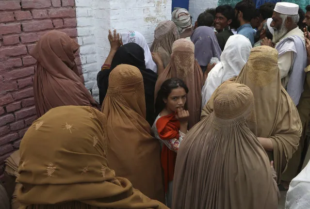 Victims of unprecedented flooding from monsoon rains line up to receive relief aid organized by The International Federation of Red Cross and Red Crescent Societies (IFRC), in Charsadda, Pakistan, Monday, September 5, 2022. (Photo by Mohammad Sajjad/AP Photo)