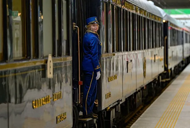 An employee stands on the step of The Venice Simplon-Orient-Express at Istanbul Station in Istanbul, on August 31, 2022. The Venice Simplon Orient-Express luxury train arrives in Istanbul, completing its annual voyage along a mythical route that takes it across Europe from Paris. (Photo by Yasin Akgul/AFP Photo)