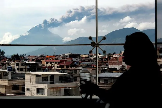 Ecuador's Tungurahua volcano spews large clouds of gas and ash near Banos as a woman is silhouetted at her office, September 11, 2015. (Photo by Carlos Campana/Reuters)