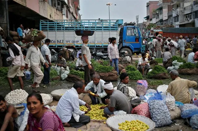 Vendors and customers crowd at a wholesale vegetable and fruit market in New Delhi July 2, 2014. (Photo by Anindito Mukherjee/Reuters)
