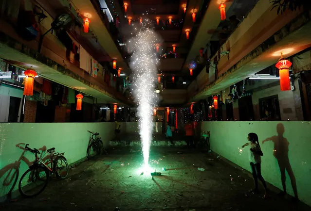 A girl plays with firecrackers while celebrating the Hindu festival of Diwali, the annual festival of lights in Mumbai, India, October 19, 2017. (Photo by Danish Siddiqui/Reuters)