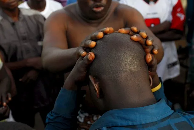 Chief priest, Gbenga Saala (top) prays for one of the worshippers of the iron god Ogun during an annual prayer and sacrifice celebration in Abuja, Nigeria June 23, 2015. (Photo by Afolabi Sotunde/Reuters)