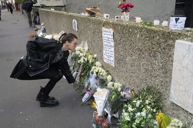 A woman lays flowers outside the building where the body of 12-year-old schoolgirl was discovered in a trunk, in Paris, Wednesday, October 19, 2022. France has been “profoundly shaken” by the murder of a 12-year-old schoolgirl, whose body was found in a plastic box, dumped in a courtyard of a building in northeastern Paris, the government spokesman Olivier Veran said on Wednesday. (Photo by Michel Euler/AP Photo)