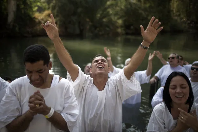 Christian pilgrims from Brazil are baptized in the water of the Jordan River during a ceremony at the Yardenit baptismal site near the northern Israeli city of Tiberias October 15, 2014. (Photo by Finbarr O'Reilly/Reuters)
