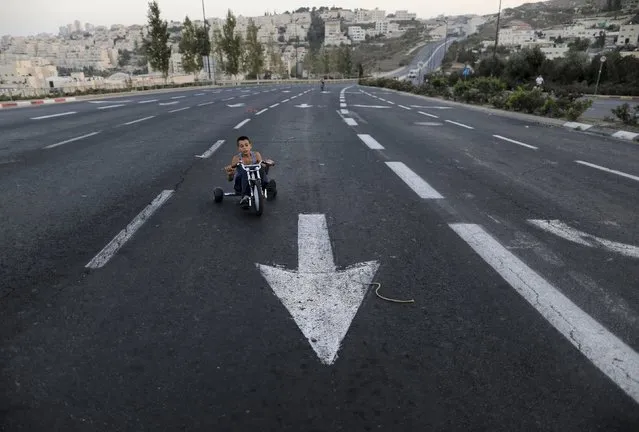 A youth rides his tricycle on an empty street during the Jewish holiday of Yom Kippur September 23, 2015. Yom Kippur, or the Day of Atonement, is the holiest of Jewish holidays, when observant Jews atone for the sins of the past year. Traffic is not allowed during the 25-hour long period. (Photo by Ammar Awad/Reuters)