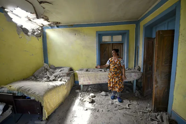A local woman shows damage in her house after the shelling by Armenian forces in the Tovuz region of Azerbaijan, Tuesday, July 14, 2020. Skirmishes on the volatile Armenia-Azerbaijan border escalated Tuesday, marking the most serious outbreak of hostilities between the neighbors since the fighting in 2016. (Photo by Ramil Zeynalov/AP Photo)