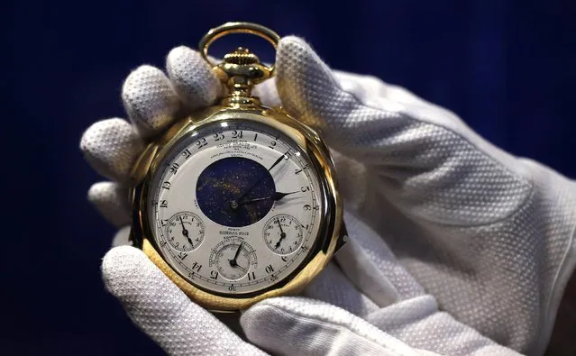 A staff member holds “The Henry Graves Supercomplication” handmade watch by Patek Philippe which was completed in 1932 at Sotheby's auction house in London October 21, 2014. (Photo by Suzanne Plunkett/Reuters)