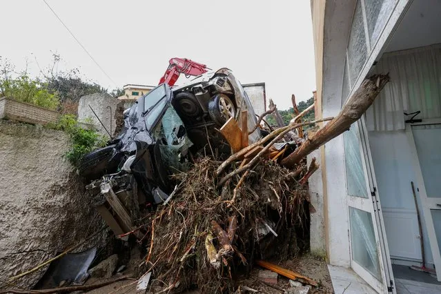 Damaged cars and debris block an alley following a landslide on the Italian holiday island of Ischia, Italy on November 26, 2022. (Photo by Ciro de Luca/Reuters)