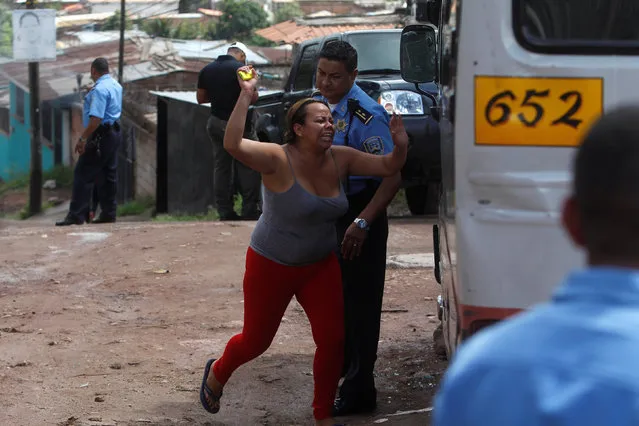 A woman reacts at a crime scene where unknown assailants gunned down her cousin, a bus driver, at a gang-infested neighbourhood in Tegucigalpa, Honduras, August 30, 2016. (Photo by Jorge Cabrera/Reuters)