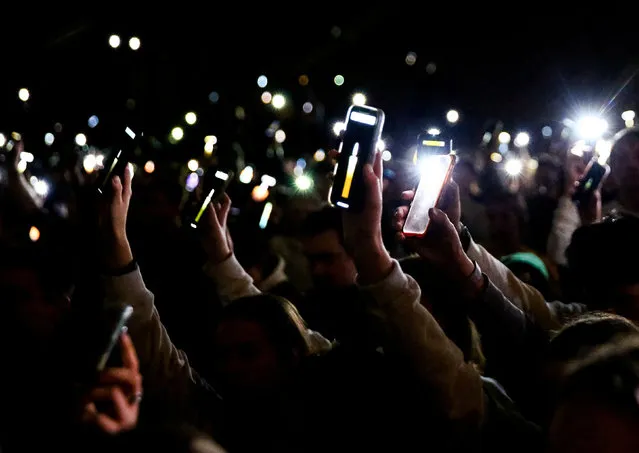 Attendees raise their phones showing digital candles to honor the victims during a vigil at the University of Idaho for four students found dead in their residence on November 13 in Moscow, Idaho, U.S., November 30, 2022. (Photo by Lindsey Wasson/Reuters)
