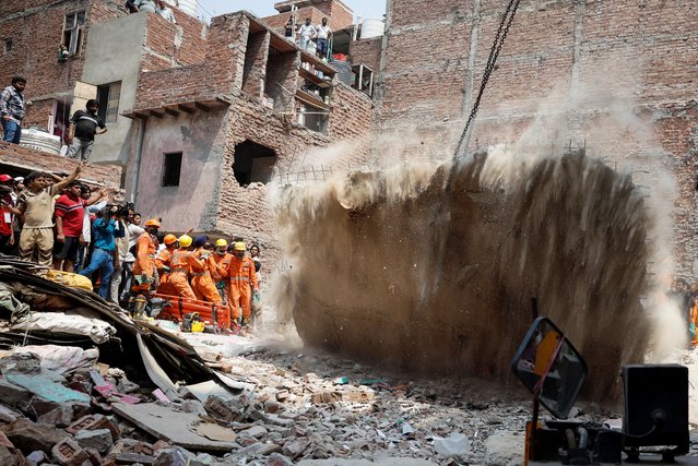 Emergency personnel use a crane to remove a slab at the site of a collapsed building in New Delhi, India, on April 19, 2025. (Photo by Adnan Abidi/Reuters)