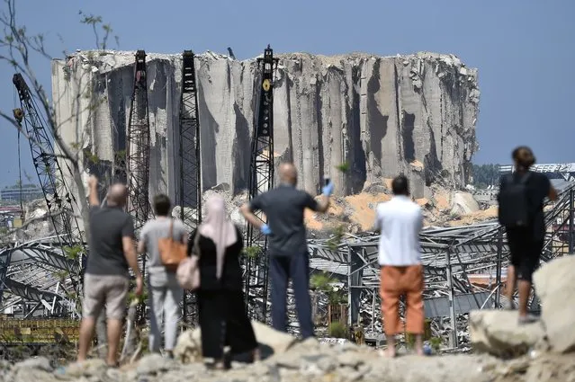 Lebanese people take pictures for damaged grain silos in Beirut port following a huge explosion rocked the city in Beirut, Lebanon, 23 August 2020. According to Lebanese Health Ministry at least 181 people were killed, and more than 6,000 injured in the Beirut blast that devastated the port area on 04 August and believed to have been caused by an estimated 2,750 tons of ammonium nitrate stored in a warehouse. (Photo by Wael Hamzeh/EPA/EFE)