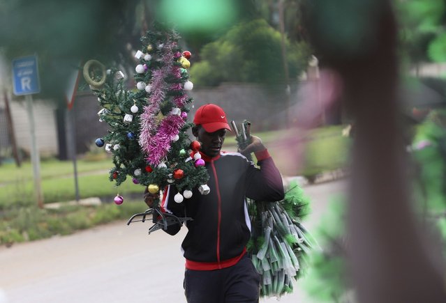 A street vendor sells Christmas decorations on a street corner in Harare, Zimbabwe, Tuesday, December 21, 2022. A buoyant holiday mood is not lifting the country which is coping with widespread power outages and the world's highest food inflation. (Photo by AP Photo/Stringer)