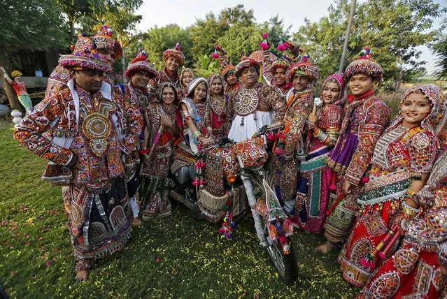 Dancers dressed in traditional attire pose with a motorcycle during a full dress rehearsal for the "garba" dance ahead of Navratri festival in Ahmedabad, India, October 9, 2015. Navratri, held in honour of Hindu Goddess Durga, is celebrated over a period of nine days where thousands of youths dance the night away in traditional costumes. Navratri starts on October 13 this year. (Photo by Amit Dave/Reuters)